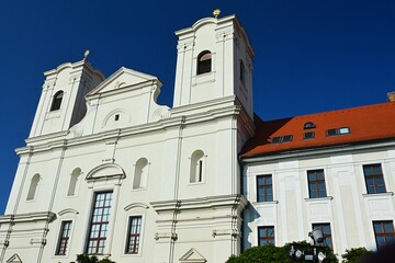 Baroque Jesuit Church Of Saint Francis Xavier in Skalica from year 1693, sunlit by afternoon summer sunshine, clear blue skies in background.