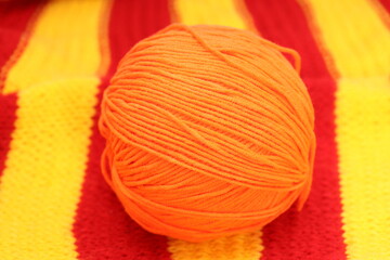 Wall Mural - an orange ball of wool lies on a knitted napkin