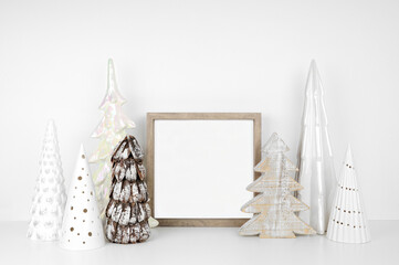 Wall Mural - Christmas mock up with wood frame and white tree decor. Square frame on a white shelf against a white wall. Copy space.