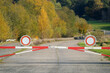Rot-weiße Schranken mit Verkehrszeichen Durchfahrt verboten auf Panzerstraße von Truppenübungsplatz an der Grenze zu Naturschutzgebiet - Stockfoto