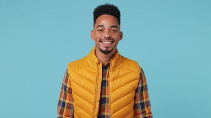 Wall Mural - Attractive young african american†man 20s years old wear yellow shirt waistcoat looking camera smiling isolated on plain pastel light blue background studio portrait. People emotions lifestyle concept