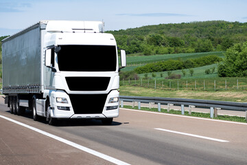 Wall Mural - White Semi-trailer driving along highway. Goods Delivery by roads. Services and Transport logistics