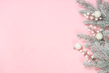 Christmas Decorations At Pink Background. Fir Tree And White Christmas Decorations Top View With Copy Space.