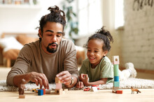 Happy African American Family Father And Child Son Laughing While Playing Toys Together At Home