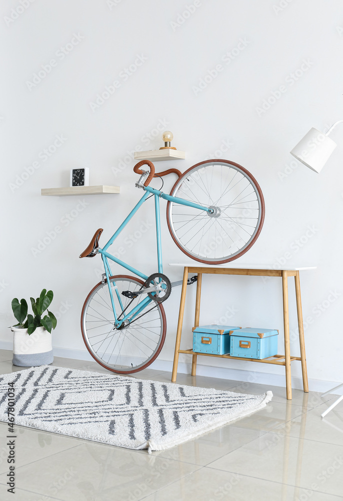 Bicycle and table with boxes near white wall
