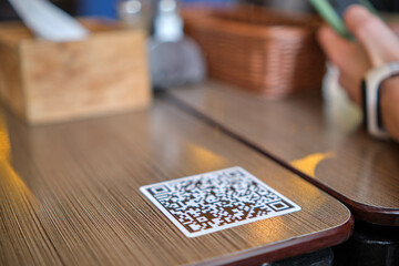 Closeup of guest hand ordering meal in restaurant while scanning qr code with mobile phone for online menu