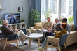 © pressmaster - Group of senior people resting on sofa in the living room and watching news on TV together