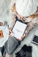 Poster - A girl writing winter words on a note book for winter concept background