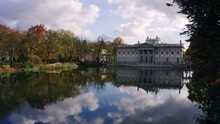 Palace On The Isle, Lazienki Royal Baths Park, Warsaw Poland. Landmark From 16th Century, Colorful Autumn Foliage And Mirror Reflection On The Lake, Revealing Shot