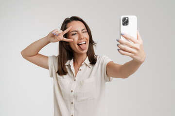 Wall Mural - Young european woman taking selfie photo on mobile phone