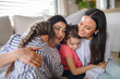© Halfpoint - Happy small girls with mother and grandmother indoors at home, hugging.