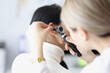 © H_Ko - Close-up of female otolaryngologist examining ear with
