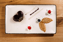 Studio Shot Of Tray With Finely Presented Chocolate Cake With Fruit And Whipped Cream Additions