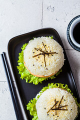 Wall Mural - Rice burger with salmon cutlet, avocado and soy sauce, top view.