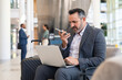 © Rido - Businessman working with phone and laptop at the airport