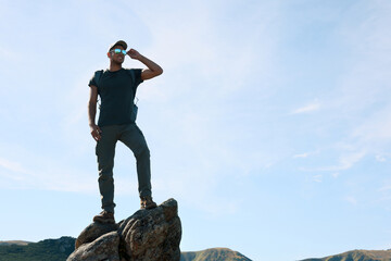 Wall Mural - Man enjoying picturesque view on cliff in mountains. Space for text