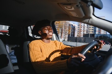 Wall Mural - Handsome young African American man in his new high-tech electric vehicle while drinking. Self driving vehicle concept