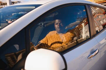 Wall Mural - African American driving an electric car.