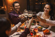 © Syda Productions - holidays, party and celebration concept - multiethnic group of happy friends having christmas dinner at home and drinking wine