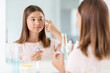 © Syda Productions - health, vision and old people concept - teenage girl applying contact lenses in front of mirror at home bathroom