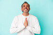 © Asier - Middle age caucasian man isolated on blue background  holding hands in pray near mouth, feels confident.