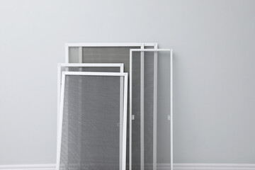 Wall Mural - Set of window screens near light grey wall indoors. Space for text