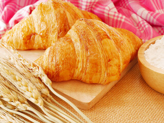 Two pieces of croissant on wooden cutting board