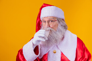 Santa Claus drinking a glass of water on yellow background with space for text. Health and hydration concept