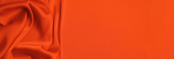Orange silk fabric as background, top view with space for text. Banner design