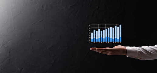 Businessman holding graph growth and increase of chart positive indicators in his business.Investment up concept.analyzing sales data and economic,strategy and planning, Digital marketing and stock 