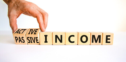 Passive or active income symbol. Businessman turns wooden cubes and changes words passive income to active income. Beautiful white background, copy space. Business, passive or active income concept.