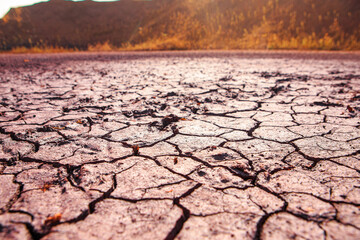 Cracked red earth during drought, the texture of earth during drought. A long time without rain. Infertile soil without plants