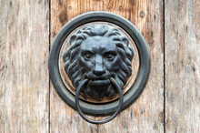 Ancient Door Knocker In The Shape Of A Lion On A Wooden Door