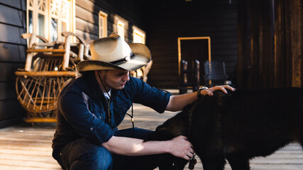 Wall Mural - man with cowboy hat petting a dog