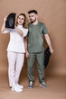© makalish - A woman and a man in medical clothing on a caramel background.