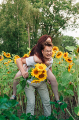 Canvas Print - Vertical shot of a Caucasian lovely couple at the sunflowers field in Ukraine