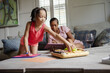 © Creative Flame - Mother and daughter spending time together in living room, girl eating snack