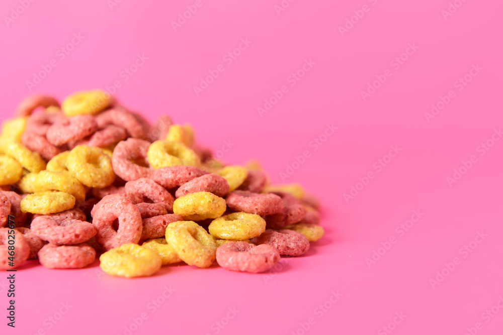 Crunchy corn flakes rings on color background