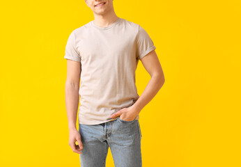 Wall Mural - Handsome young man in stylish t-shirt on color background