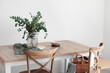 © Pixel-Shot - Dining table with eucalyptus branches in vase near light wall