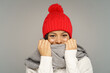 © DimaBerlin - Funny woman in sweater, knitted woolen hat and scarf covering face. Joyful african american female wearing warm clothes for cold weather and frost. Isolated studio portrait of cute cheerful black girl