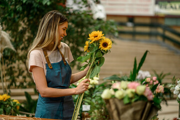 Wall Mural - Florist woman making a bouquet of fresh flowers in a flower shop