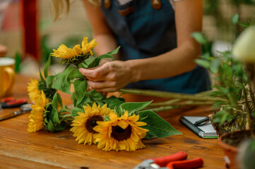 Wall Mural - Florist woman making a bouquet of fresh flowers in a flower shop