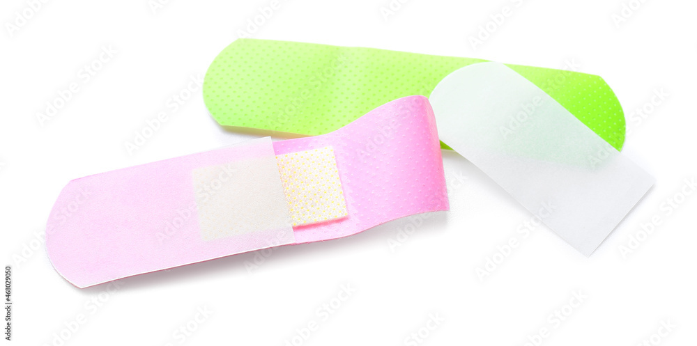 Green and purple medical plasters on white background
