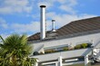 Schornstein, Außenkamin aus Edelstahl am Dach eines Wohnhauses