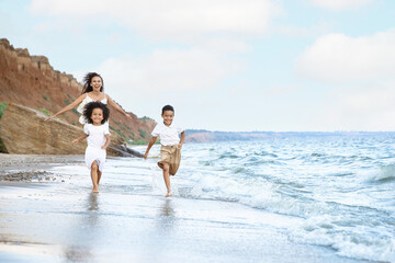 Sticker - African-American children with mother running on sea beach