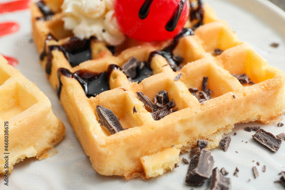 Tasty Belgian Waffles with berries and chocolate on plate, closeup