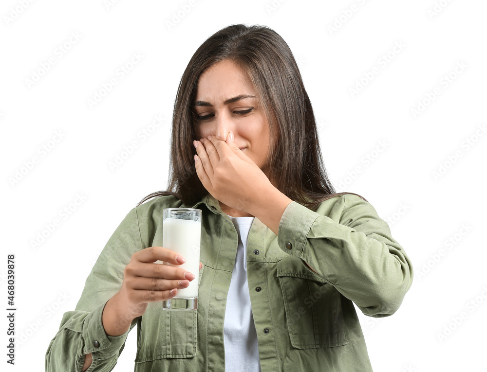Young woman refusing to drink milk on white background