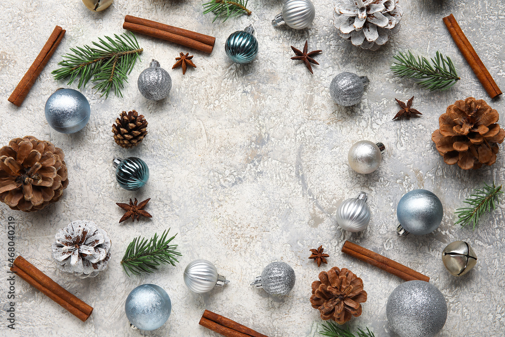 Frame made of Christmas balls, pine cones, fir tree branches and cinnamon on light background