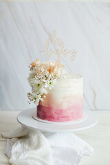 Poster - Beautiful boho pastel cake with a topper and flowers on a white table